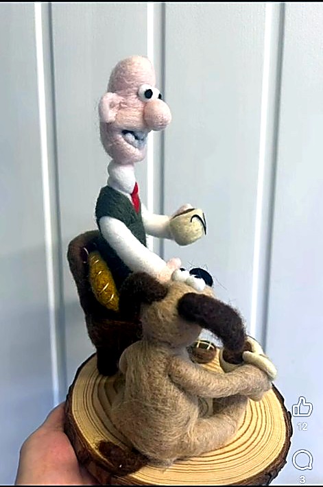 Wallace in an armchair with Gromit