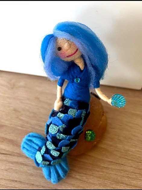 Blue-haired mermaid on a rock